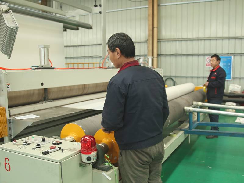 Two workers are operating the production machine.