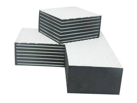 Two parts of rectangular PTFE bearing pad: one is standing on the other, showing inner structure.